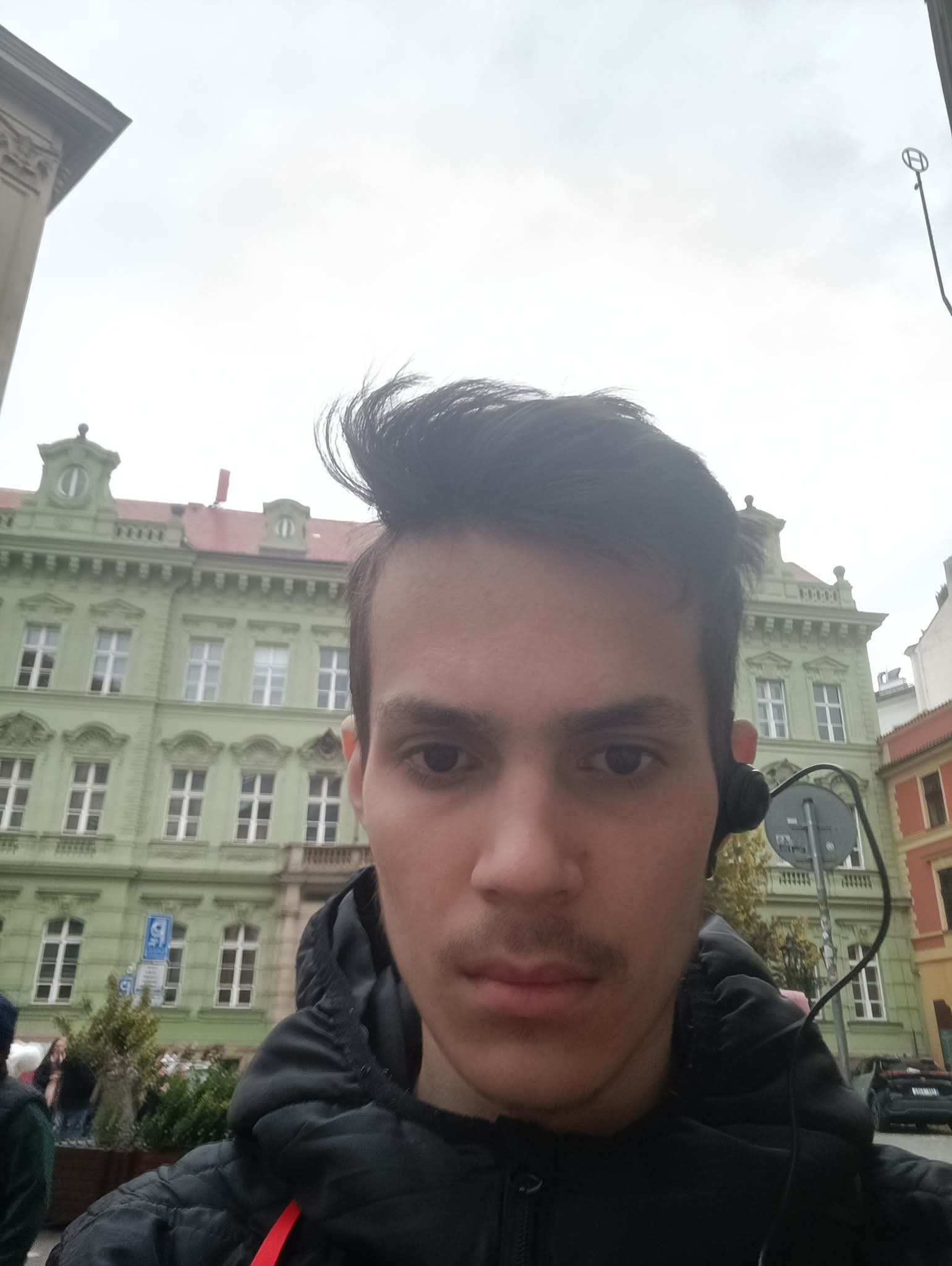 Yaroslav Ostapenko na tle kolorowych kamienic w Pradze